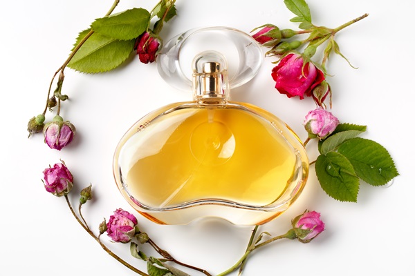perfume bottle surrounded by roses