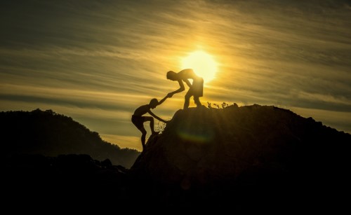 inclusive as possible teamwork at sunset mountaintop